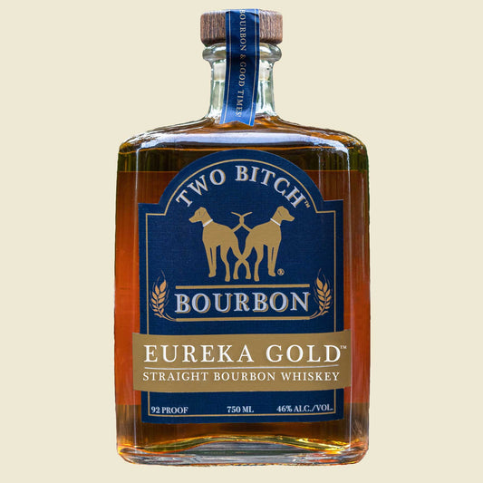 Bottle of Two Bitch Bourbon Eureka Gold on a beige background